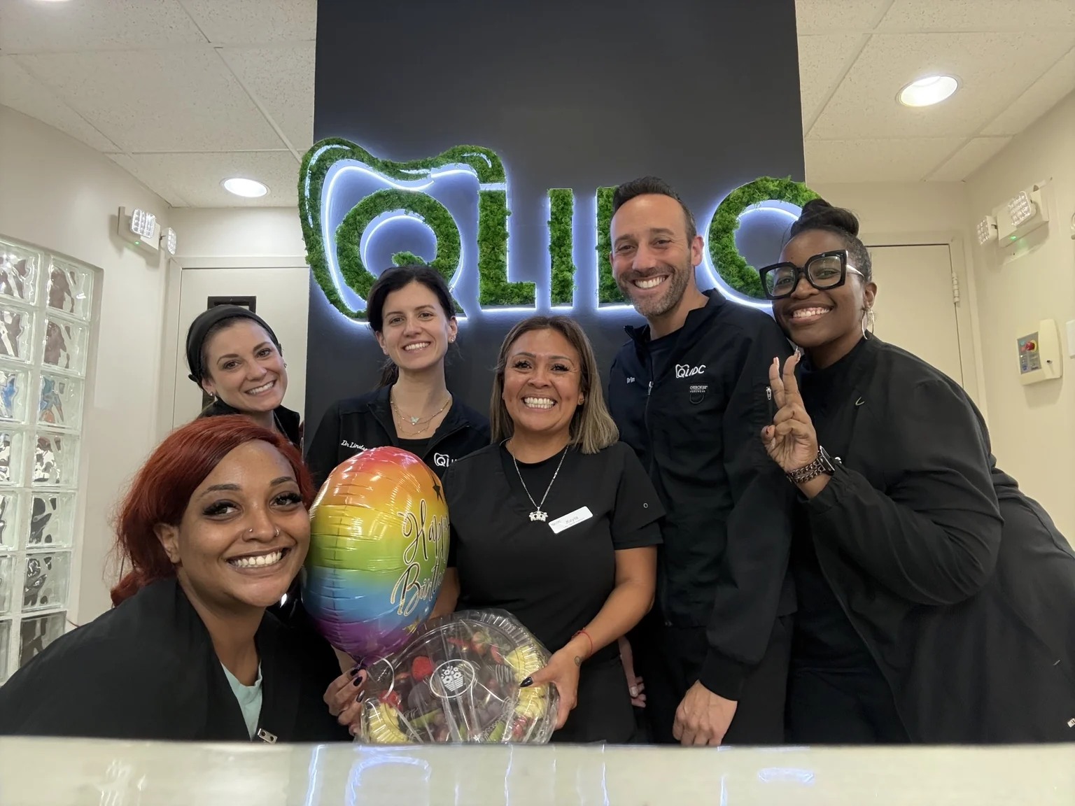 The QLIDC team celebrating together in the office with a birthday balloon